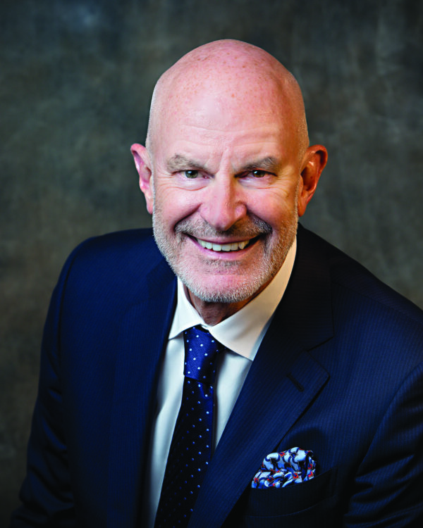Closeup smiling headshot of Dr. Jack Wiley wearing a blue suit